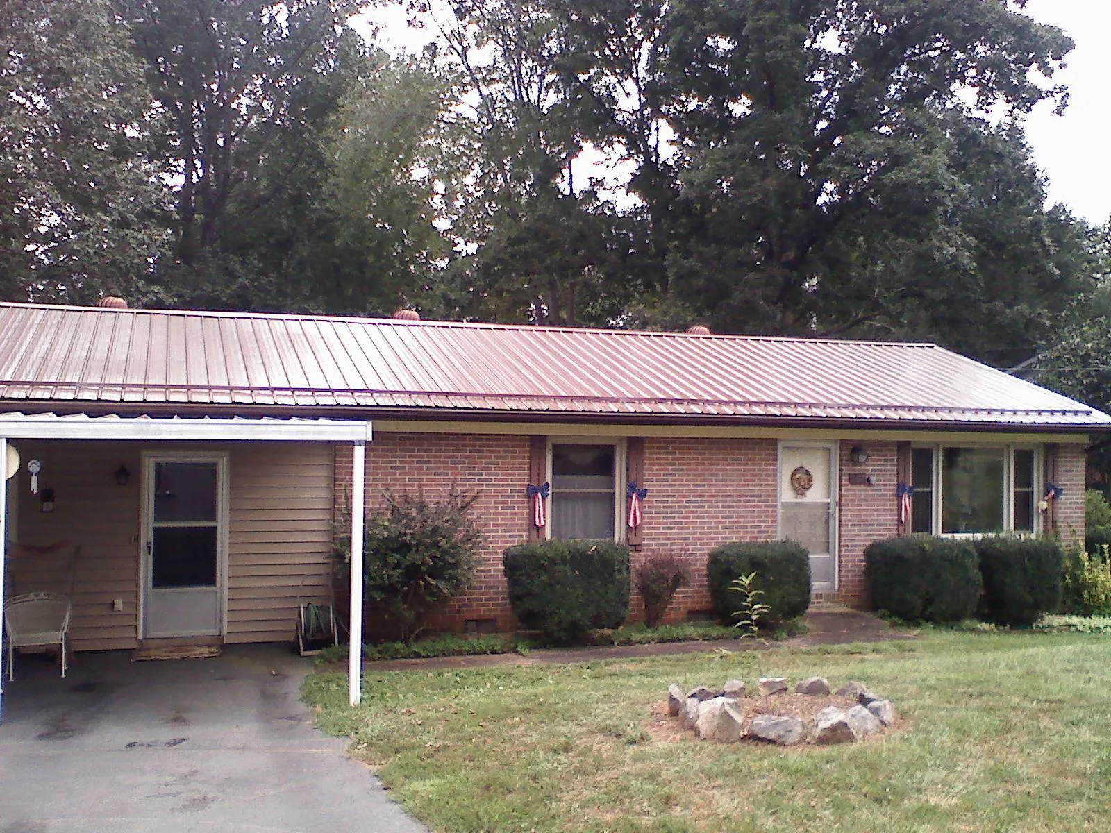 Bronze metal roof and carport on a brick ranch home — Roof Repair work by our crew in Modoc